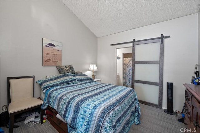 bedroom featuring carpet, a barn door, and a textured ceiling