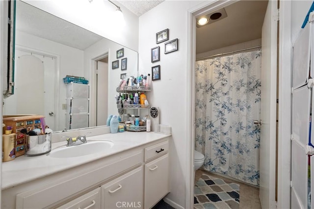 bathroom with toilet, a textured ceiling, walk in shower, and vanity