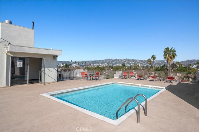 view of pool featuring a patio area and a mountain view