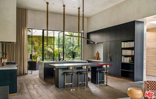 dining area with a high ceiling, light hardwood / wood-style flooring, and sink