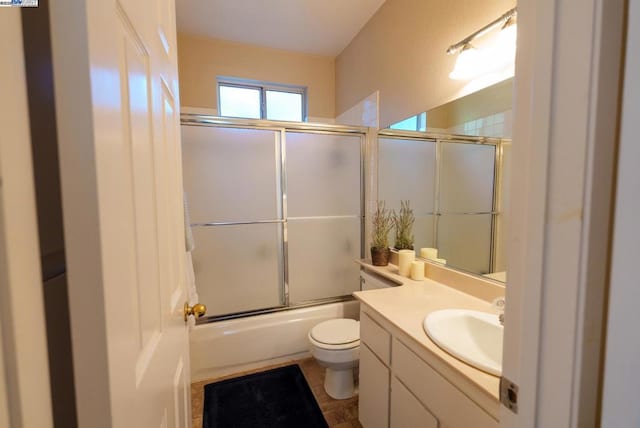 full bathroom with toilet, enclosed tub / shower combo, and vanity