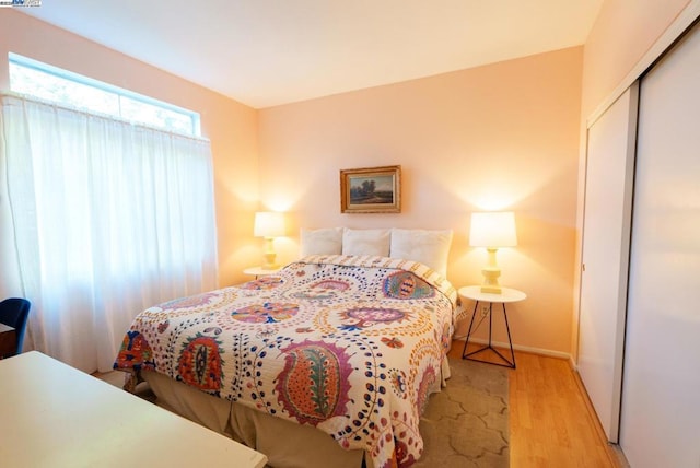 bedroom with light wood-type flooring and a closet