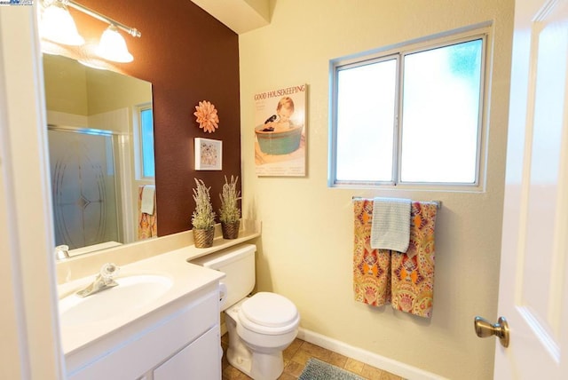 bathroom with tile patterned floors, an enclosed shower, vanity, and toilet