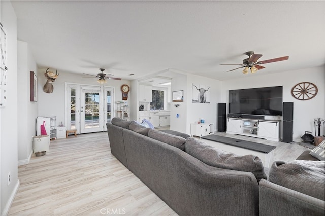 living room featuring light hardwood / wood-style floors, ceiling fan, and french doors