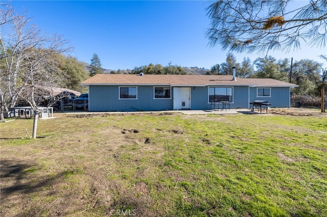 rear view of house with a lawn and a patio area