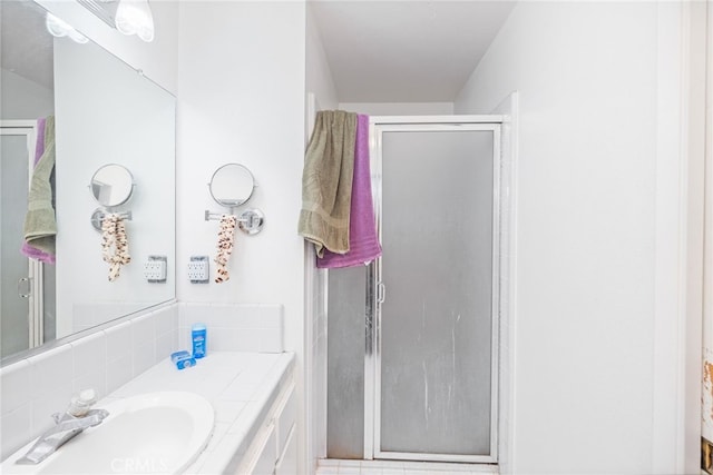 bathroom featuring vanity, walk in shower, and decorative backsplash