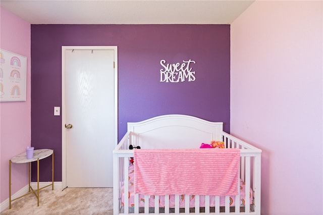 bedroom featuring a nursery area and carpet flooring