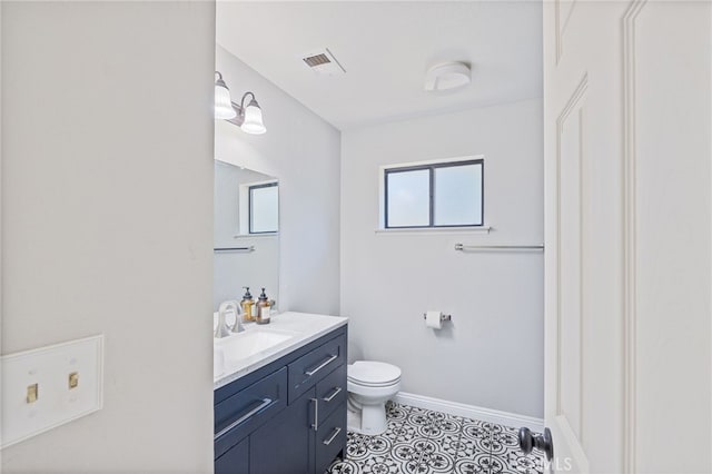 bathroom with toilet, tile patterned floors, and vanity