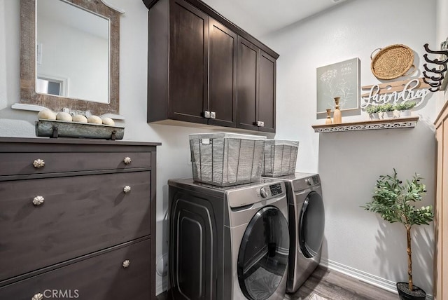 clothes washing area featuring cabinets, hardwood / wood-style floors, and independent washer and dryer