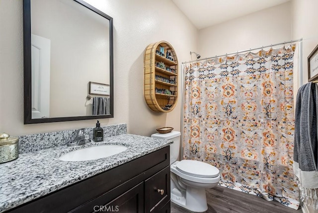 bathroom featuring a shower with curtain, hardwood / wood-style floors, vanity, and toilet