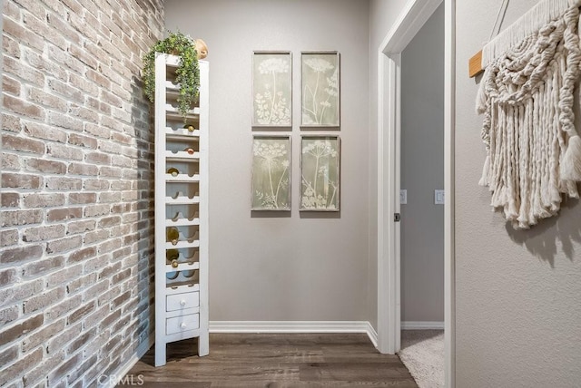 interior space featuring brick wall and dark hardwood / wood-style flooring