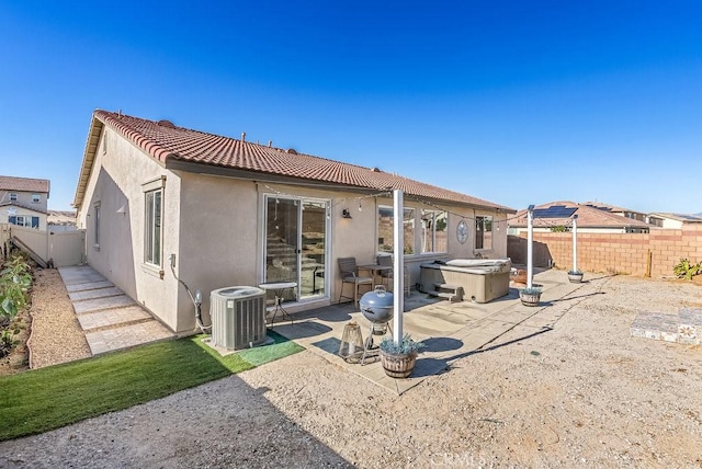 rear view of house featuring a hot tub, central AC, and a patio