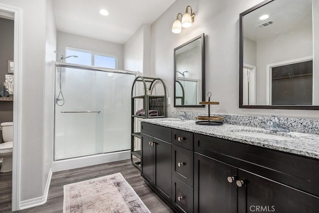 bathroom with walk in shower, toilet, vanity, and wood-type flooring