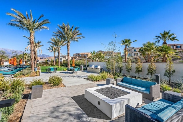 view of patio with an outdoor living space with a fire pit and a mountain view