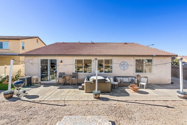 back of house with central AC, a patio area, a hot tub, and an outdoor hangout area