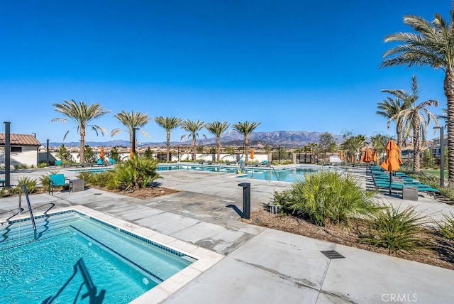 view of swimming pool featuring a patio and a mountain view