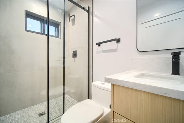 bathroom with vanity, a shower with shower door, and toilet