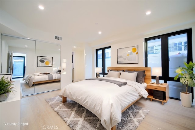 bedroom with light hardwood / wood-style flooring and a closet