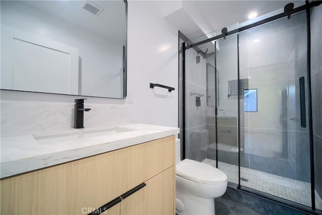 bathroom with vanity, walk in shower, and toilet