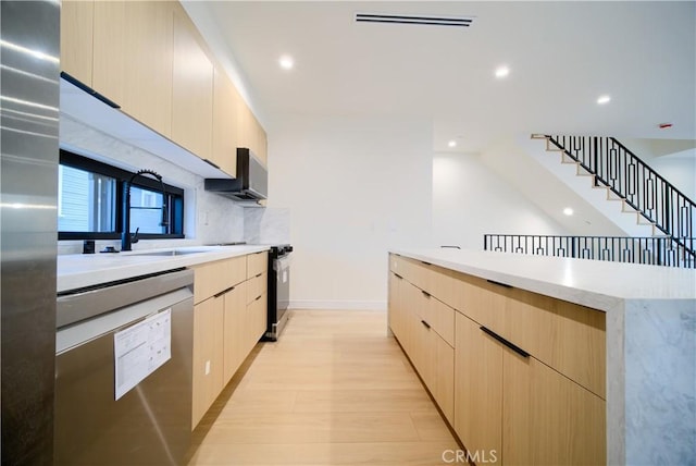 kitchen with tasteful backsplash, sink, stainless steel appliances, and light brown cabinets