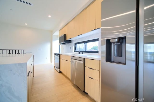 kitchen featuring light brown cabinetry, sink, light hardwood / wood-style flooring, and stainless steel appliances