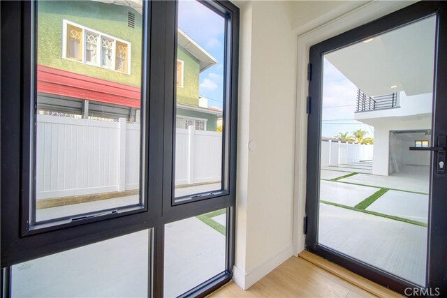 doorway to outside featuring a healthy amount of sunlight and light hardwood / wood-style flooring