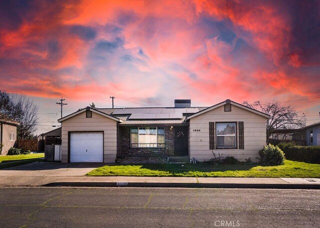 single story home featuring a garage and solar panels