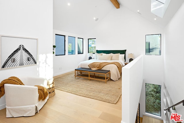 bedroom featuring high vaulted ceiling, beam ceiling, and light hardwood / wood-style flooring