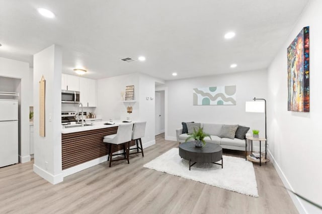 living room with sink and light hardwood / wood-style floors