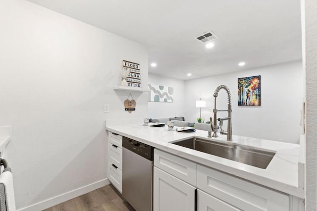 kitchen with sink, light hardwood / wood-style flooring, dishwasher, white cabinetry, and light stone countertops