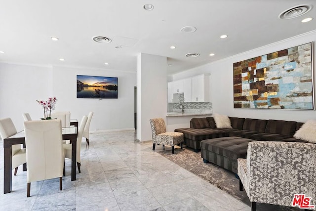 living room with ornamental molding and sink