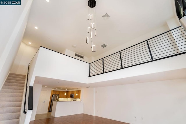 unfurnished living room with hardwood / wood-style flooring and a high ceiling