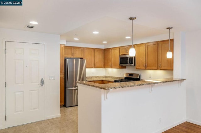 kitchen with stainless steel appliances, a kitchen breakfast bar, light stone countertops, decorative light fixtures, and kitchen peninsula