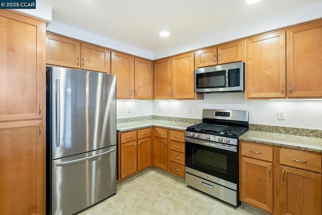 kitchen with stainless steel appliances and light stone countertops