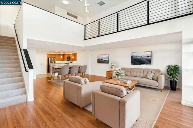 living room featuring light hardwood / wood-style floors and a high ceiling