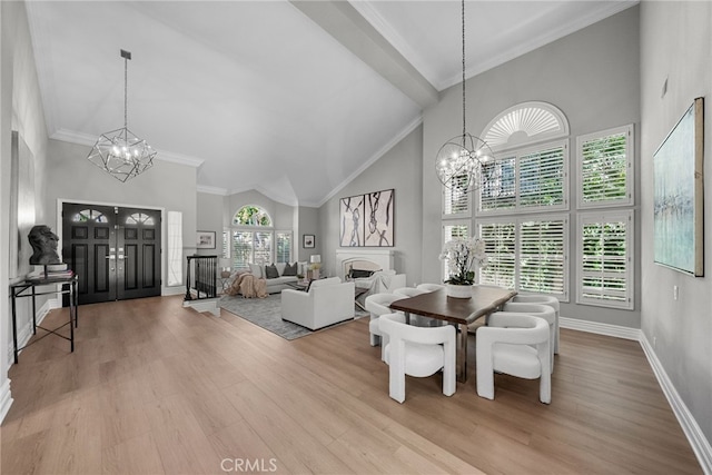 dining room featuring light wood-type flooring, an inviting chandelier, and high vaulted ceiling