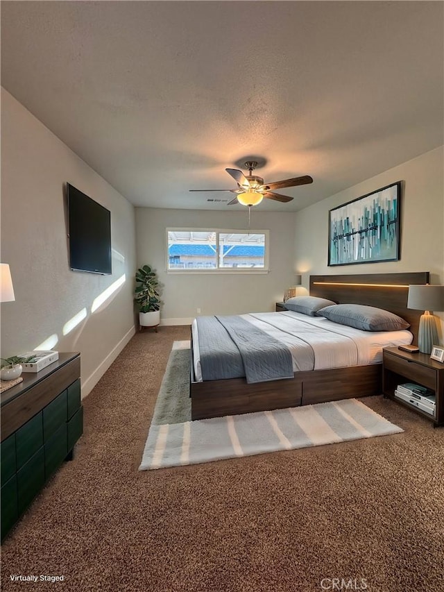 carpeted bedroom with ceiling fan and a textured ceiling