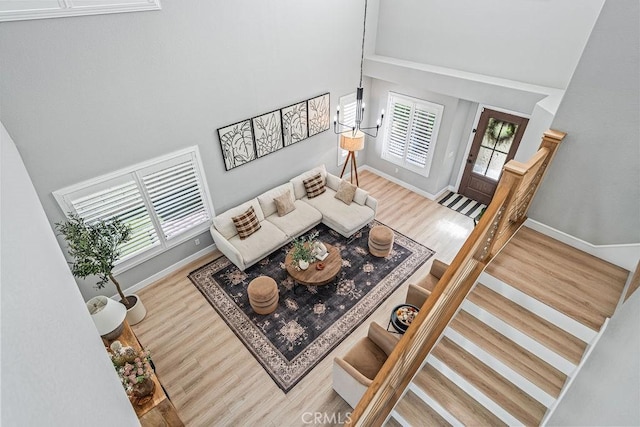 living room with a towering ceiling and hardwood / wood-style floors