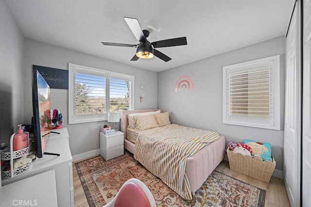 bedroom with ceiling fan and light hardwood / wood-style floors