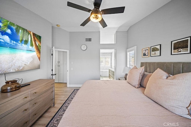 bedroom with ensuite bathroom, light wood-type flooring, and ceiling fan