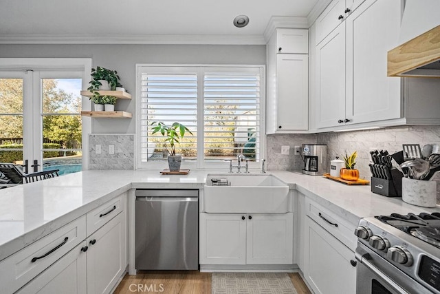 kitchen featuring custom exhaust hood, appliances with stainless steel finishes, ornamental molding, white cabinets, and sink