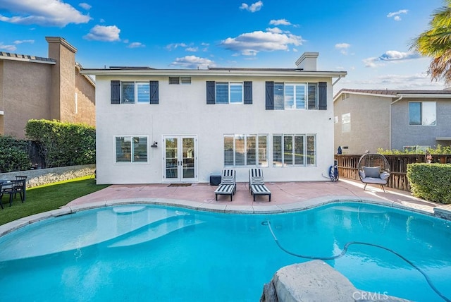 rear view of property featuring a fenced in pool