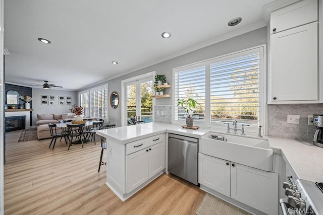 kitchen with stainless steel appliances, white cabinetry, sink, and kitchen peninsula