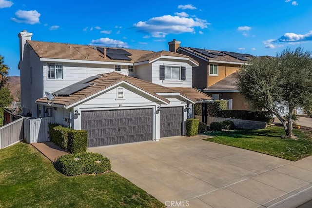 view of front property with solar panels, a front yard, and a garage