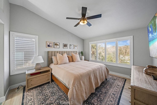 bedroom featuring light hardwood / wood-style floors, ceiling fan, and vaulted ceiling