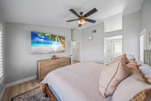 bedroom with ensuite bath, ceiling fan, and hardwood / wood-style flooring