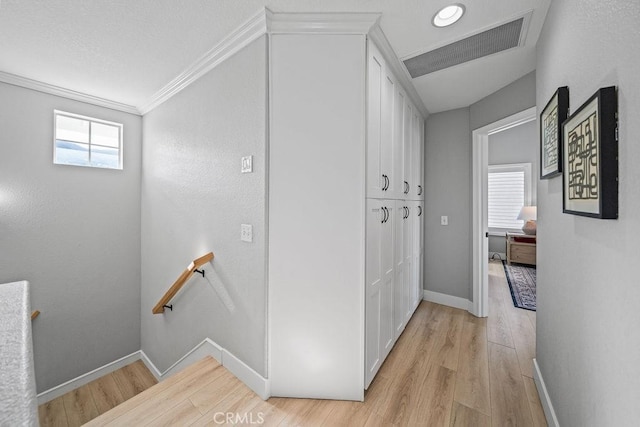 hall with light wood-type flooring and crown molding