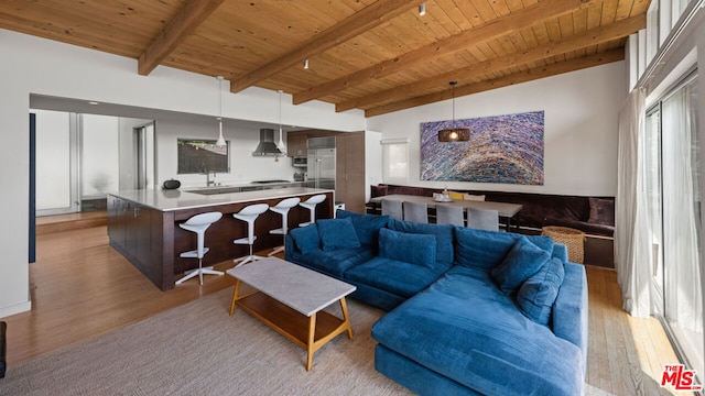 living room with beam ceiling, light hardwood / wood-style floors, and wooden ceiling