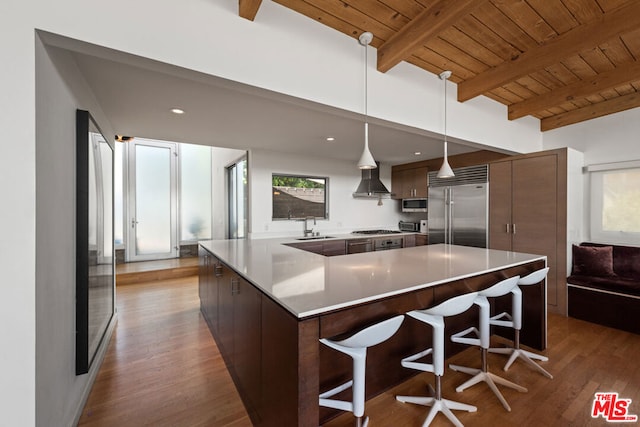 kitchen with stainless steel appliances, sink, hanging light fixtures, wood ceiling, and beam ceiling