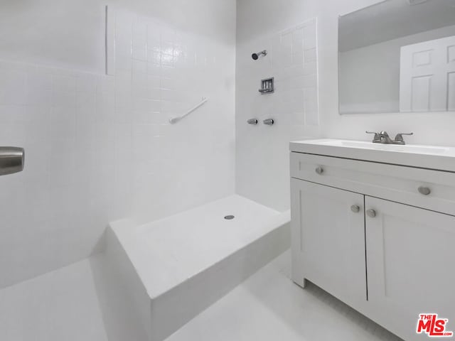 bathroom with vanity and tiled shower